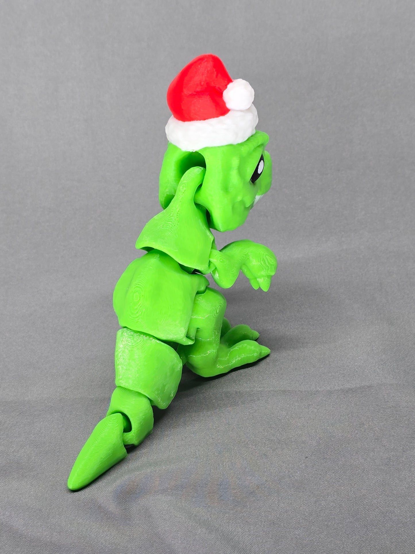 Tiny T-Rex Santa articulating figurine decoration will bring a lot of joy with a lot of teeth!
